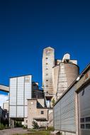 Empty factory, in light, at blue sky with white clouds on background