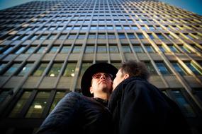 Couple, kissing near the shiny building, in Moscow, Russia, under the blue sky