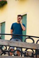 Man with glasses, talking on the phone, on the beautiful balcony