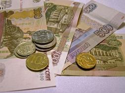 Russian banknotes and coins on a white table