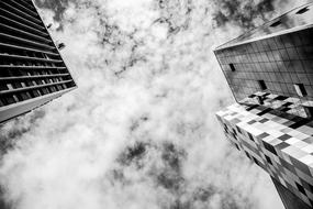 Black and white photo of the low angle shot of the buildings and beautiful, cloudy sky