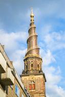 Beautiful and colorful tower, at blue sky with white clouds on background, in Copenhagen, Denmark
