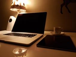 laptop on the desk near the table lamp