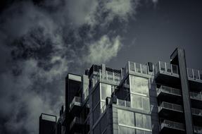 black and white photo of clouds over city building