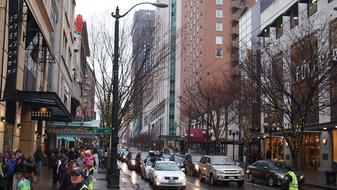 People and cars among the trees and buildings, in the downtown of Seattle, USA, after the rain