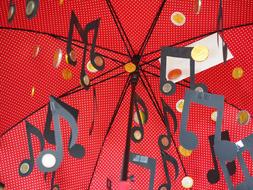 musical notation and coins near the red umbrella