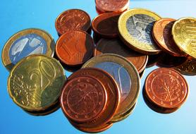 Close-up of the colorful, shiny, metal Euro coins, on blue surface, in light