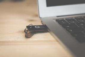 Close-up of the USB in the Macbook, on the wooden table