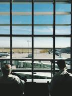 men near the window at the airport