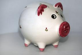 Red, white and green piggy bank with beautiful red rose with green leaves