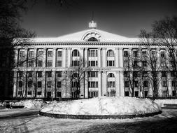 Black and white photo of the Finance University among the trees, in snow, in Russia, in the winter