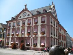 People, near the beautiful and colorful hotel in Offenbach, Germany, with the plants, under the blue sky