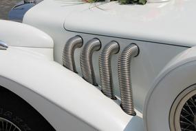 Close-up of the beautiful, white, vintage car with details, in sunlight