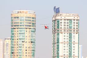 helicopter in flight between contemporary apartment Buildings