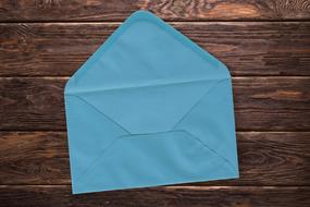 blue envelope lies on a wooden table