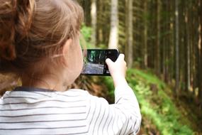 girl photographs the forest