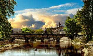 stone Bridge across calm River in old city, france