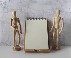 wooden dolls and notebook for notes on the table