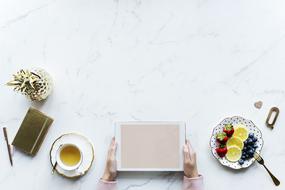 hold tablet in hand while having breakfast