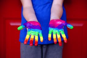 rainbow paint on the hands of a child