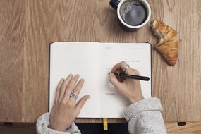 hands of girl writing on notebook, top view