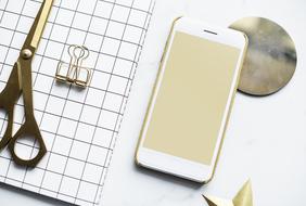 notepad, scissors and smartphone on the table