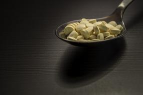 yellow small Pills On Spoon
