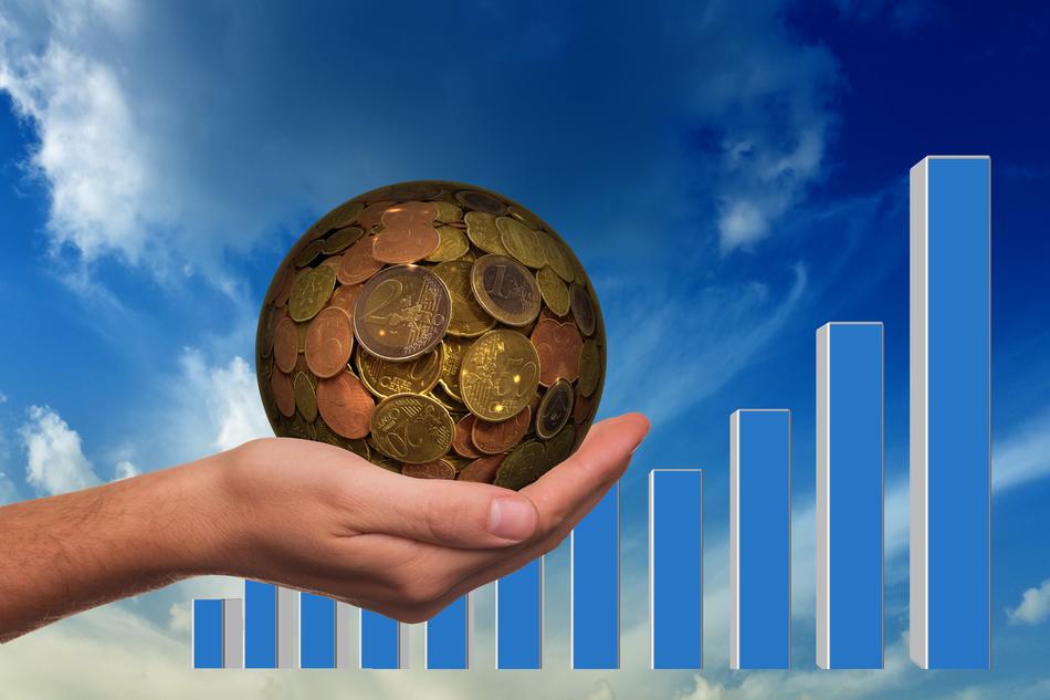 ball of coins in hand on the background of the graph