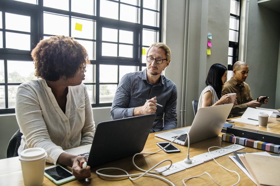 Colleagues, sitting at the workspace with the devices