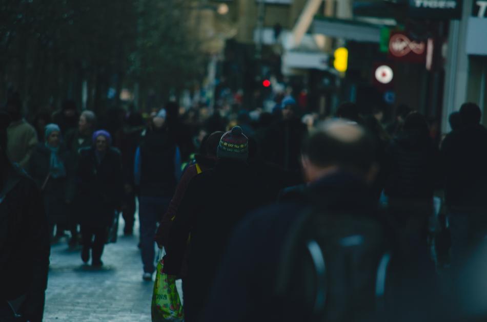 People, walking on the street, with the colorful signs, in the evening