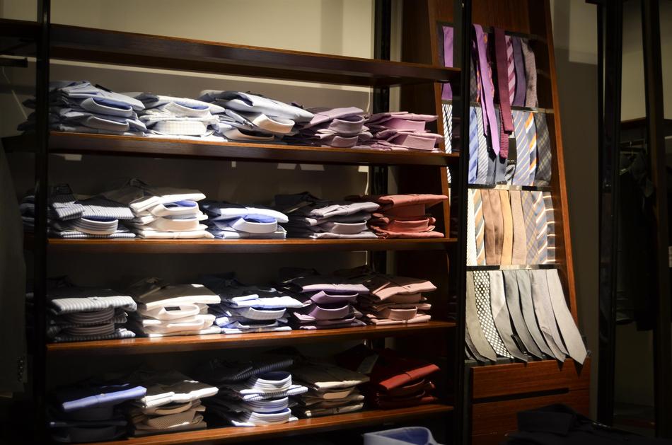 Colorful shirts and ties on the shelves, in the shop