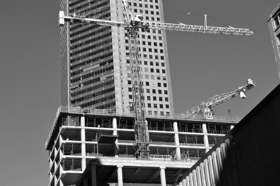 black and white photo of a construction crane near a building