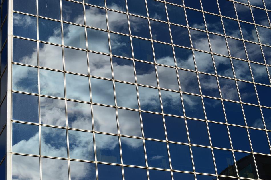 mirror reflection of clouds in the glass facade of the building