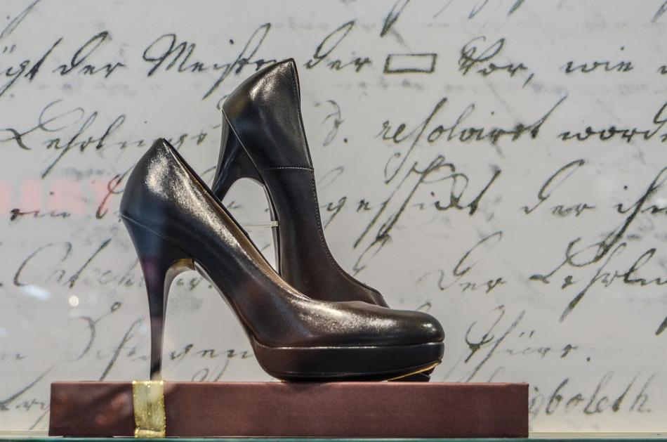 Glossy, black shoes on the stand, near the latter, on the exhibition