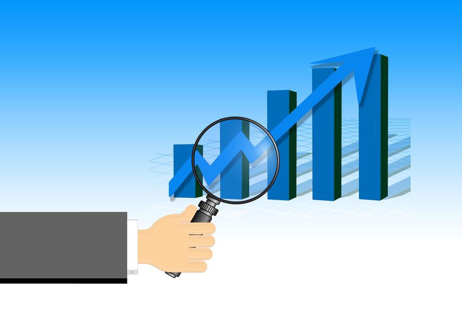 image of hand with magnifying glass on chart background