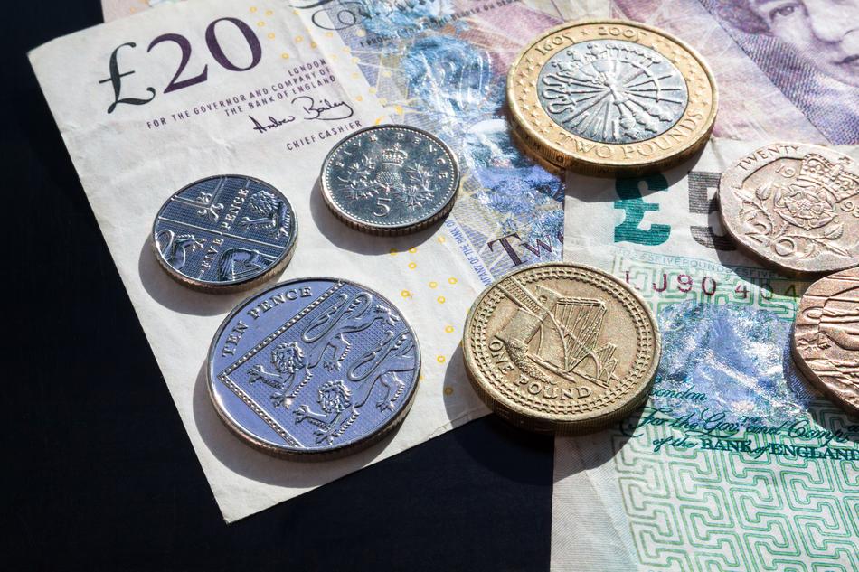 Colorful, shiny coins on the colorful Pound banknotes