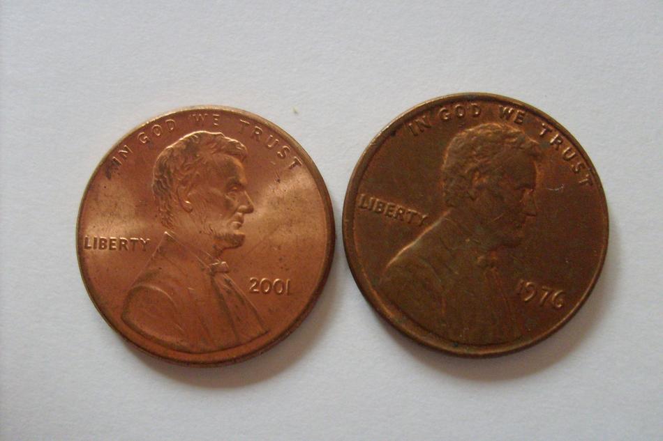 Beautiful, shiny pennies, in light, on the white surface, with the profile portraits