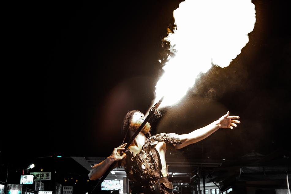 man performing on stage with fire at night