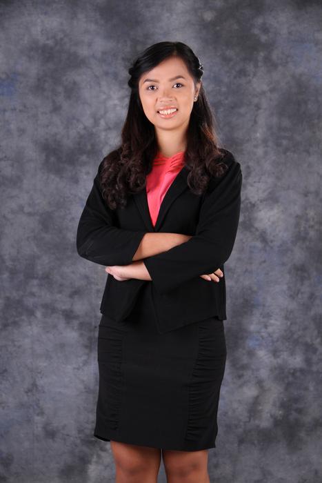 Smiling woman in black suit, at gray background