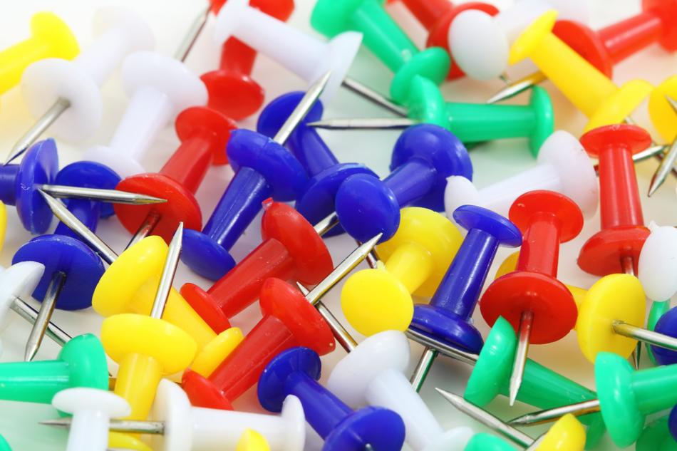 Close-up of pile of the colorful, shiny pins, in light
