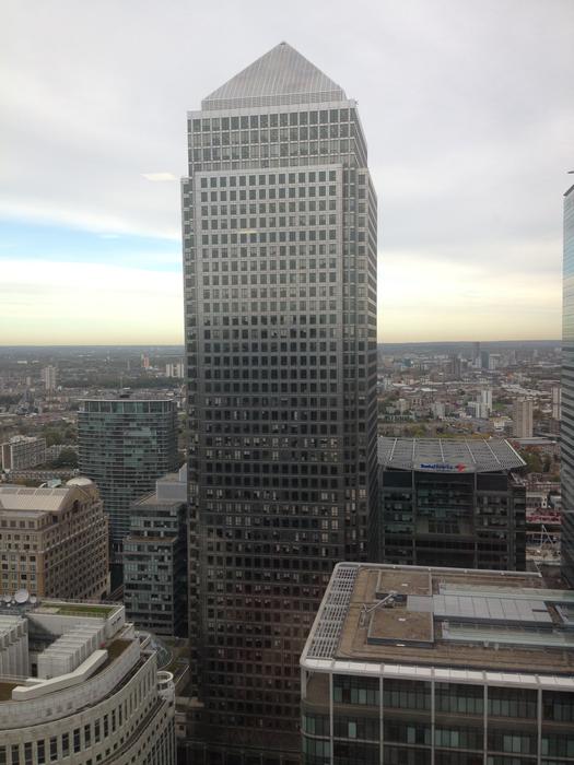 Cityscape with shiny Canary Wharf building in London, England, under the clouds