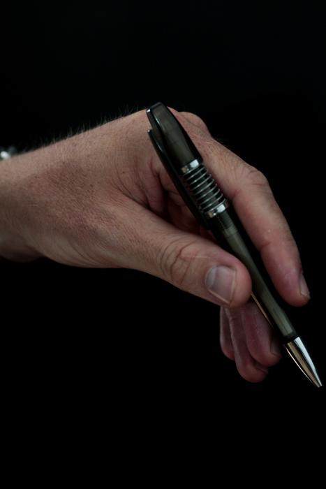 fountain pen in hand on black background