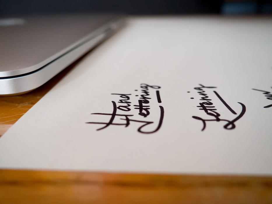 lettering on paper on table in office in blurred background