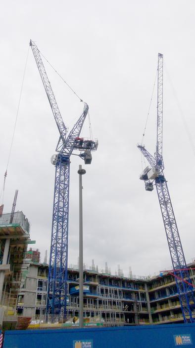 Cranes at the construction site, under the sky with clouds