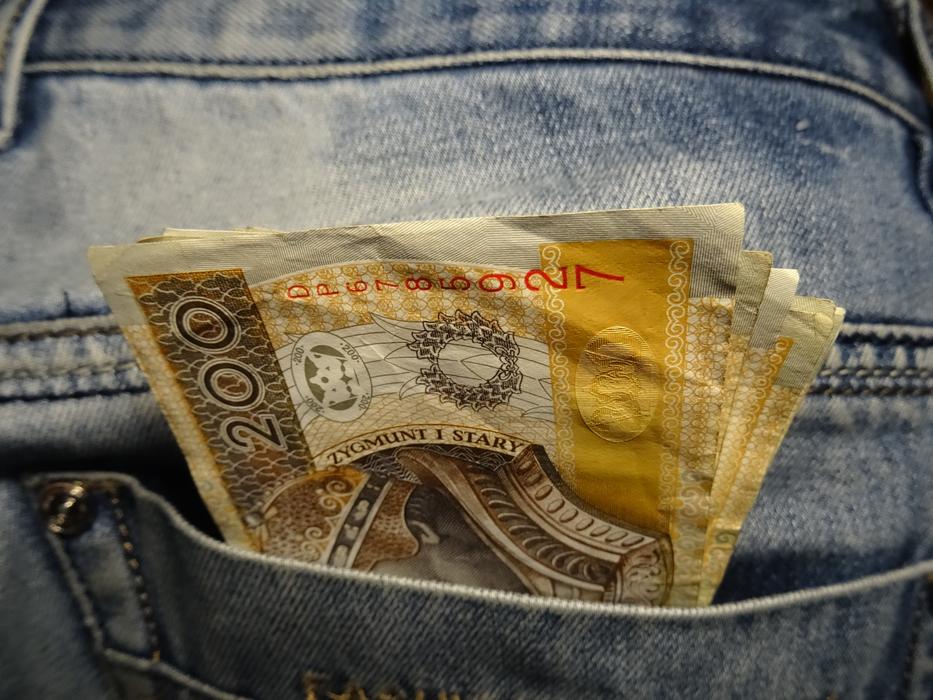 Close-up of the colorful banknotes in the pocket of the jeans