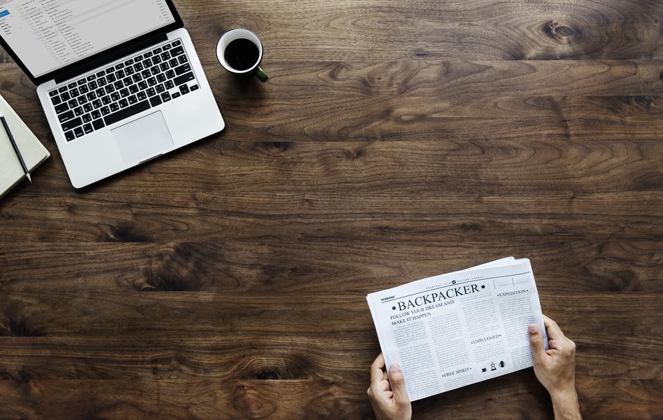 reading a newspaper while sitting at a table