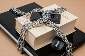 book with laptop and phone in chains