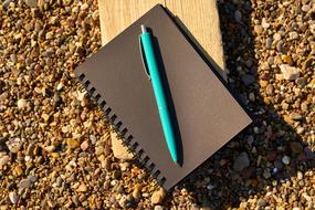 blue Pen on brown Notebook