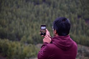 young Boy Taking Photo of landscape with smartphone