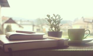 Coffee and Notebook on Wooden window sill in countryside